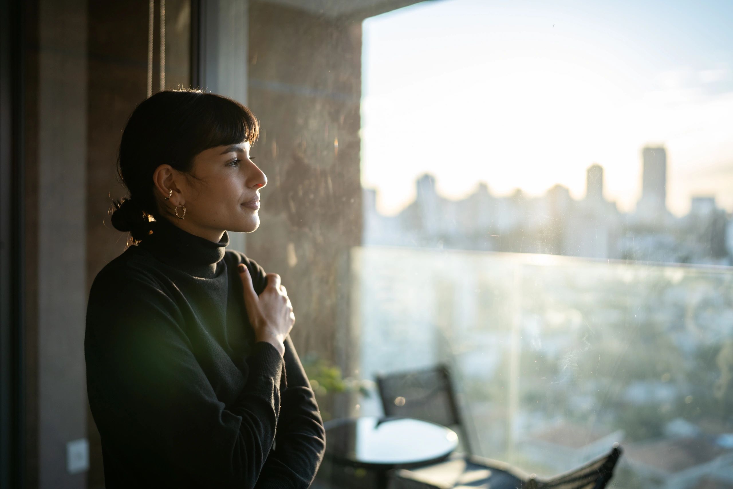 Woman journaling by a window in warm light