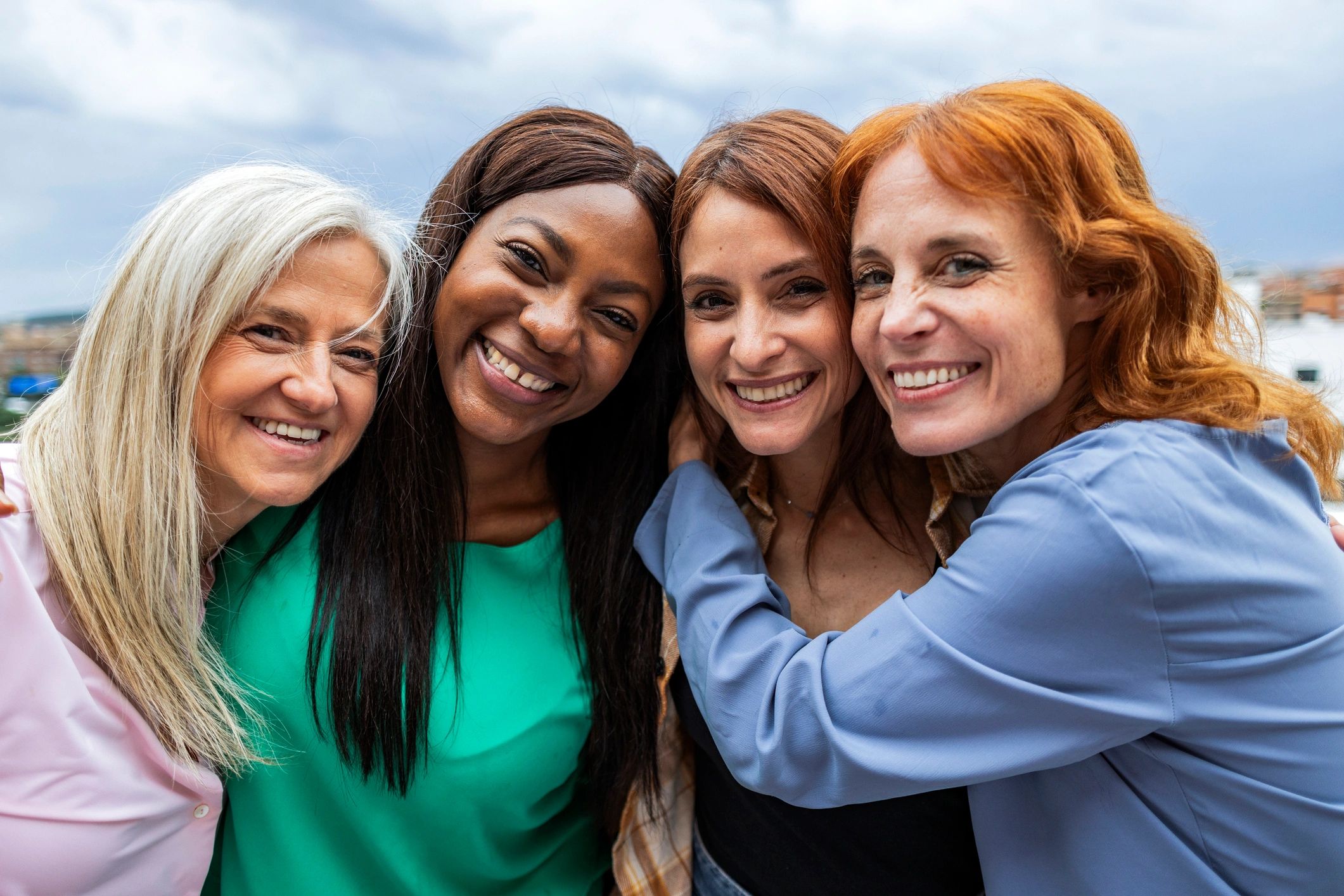 Friends embracing outdoors in a supportive group