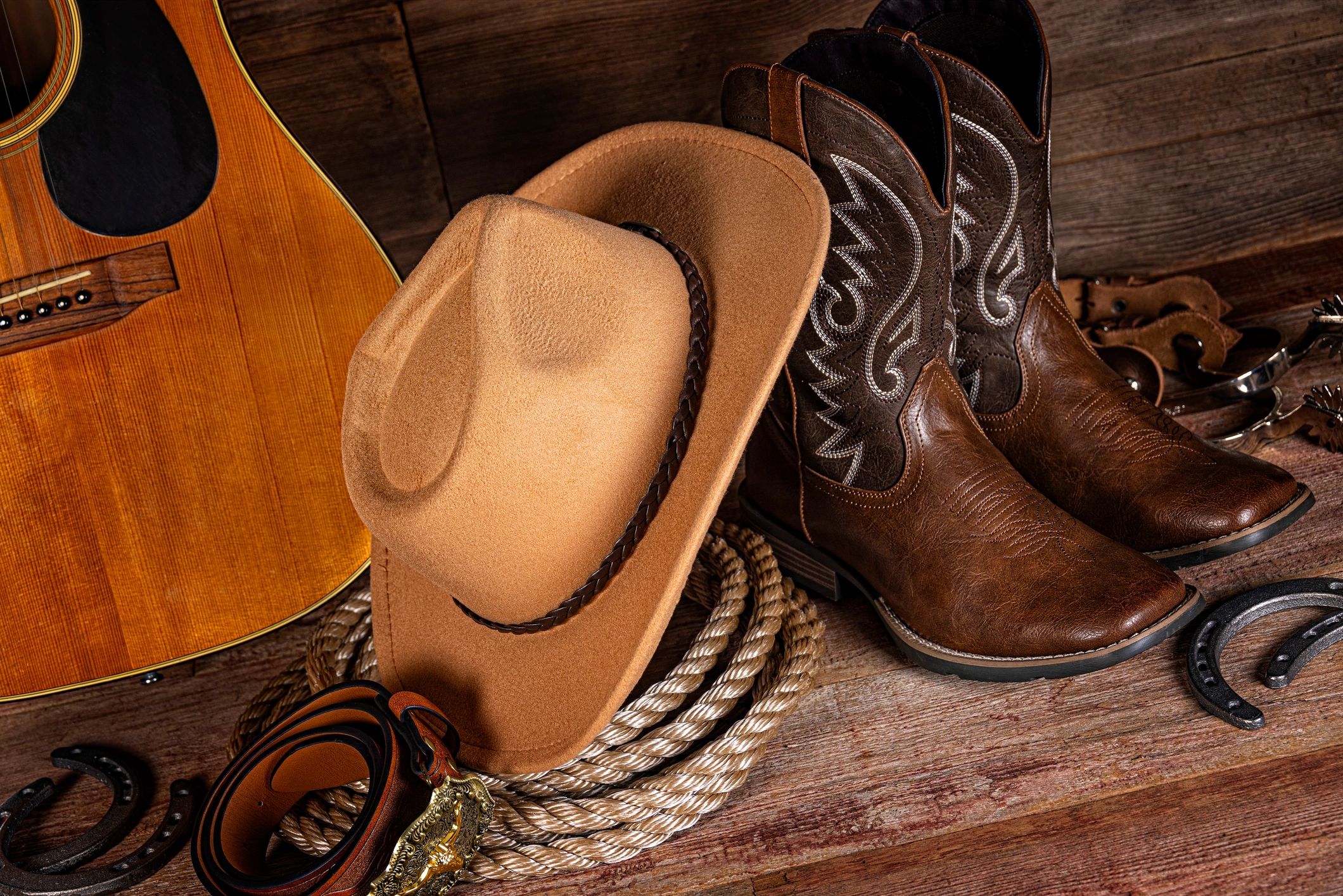 Western still life with boots and hat on rustic wood